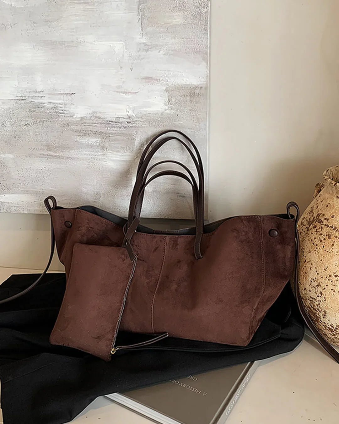 Brown suede tote bag with matching pouch and double handles on a neutral background